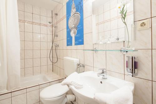 a bathroom with a toilet and a sink and a shower at Hotel Marco Polo in Hamburg