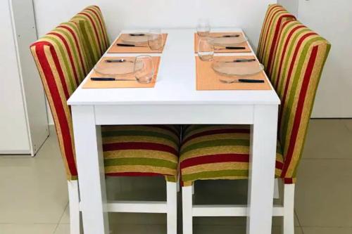 Una mesa blanca con dos sillas con gafas. en Modern Studio in heart of Recoleta with pool, grill and gym en Buenos Aires