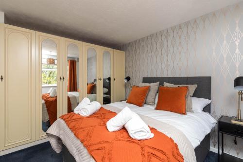 a bedroom with a large bed with towels on it at Findon House- 3BR 10mins close to Airport in Crawley