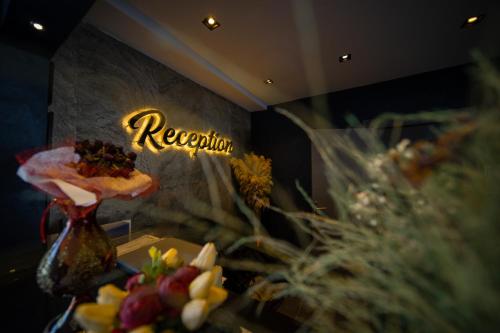 a room with flowers and a sign that says reception at Sea Palm Otel Yalıkavak in Yalıkavak