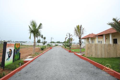 an empty road with a house and palm trees at AS Garden Villa in Ranipet