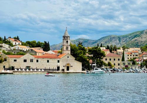 a town with a church and a large body of water at Villa Lizza in Cavtat