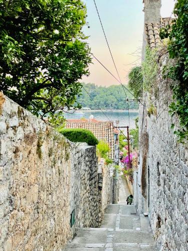 an alleyway between stone walls with a view of the water at Villa Lizza in Cavtat