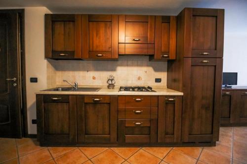 a kitchen with wooden cabinets and a sink at Residence Aquila - Bilo Monte Rena in Brusson