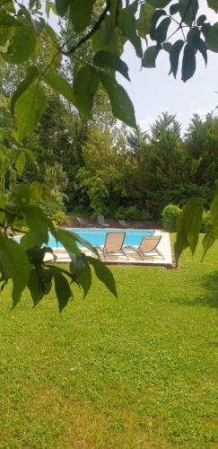 a pool with two lounge chairs in the grass at Chambre Maddy - Au Clos de Parranquet in Parranquet