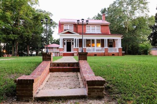 a red brick house on a grassy field at Historic House on the HillDownstairs ONLY in Tuskegee