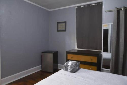 a bedroom with a bed and a dresser and a window at Historic House on the HillDownstairs ONLY in Tuskegee