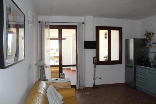 a living room with a couch and two windows and a television at Appartamento Le Vele in Porto San Paolo