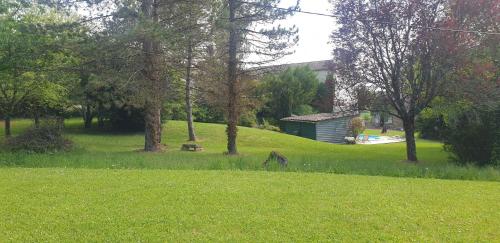 a yard with trees and a building in the background at Chambre Maddy - Au Clos de Parranquet in Parranquet