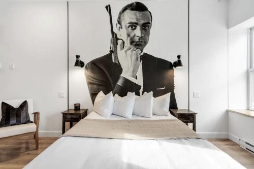 un lit avec une photo en noir et blanc d'un homme dans l'établissement INITIAL - JAMES BOND 007 - Centre ville de Quebec, à Québec