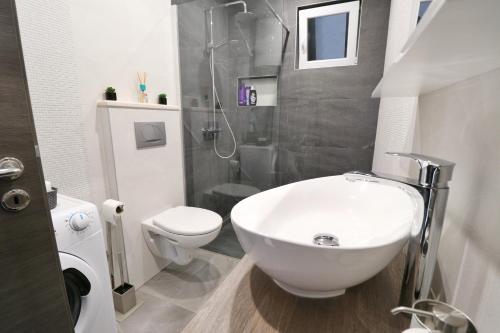 a bathroom with a sink and a toilet and a shower at Casa Bella in Split