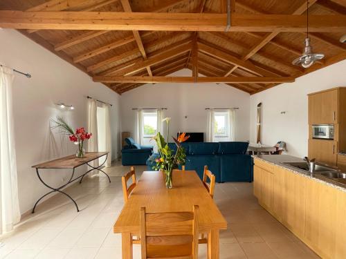 a kitchen and living room with a wooden table and chairs at A QUINTA DAS FLORES: Casa do Corvo in Santa Cruz das Flores