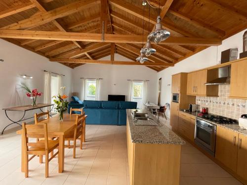 a kitchen with wooden ceilings and a table and chairs at A QUINTA DAS FLORES: Casa do Corvo in Santa Cruz das Flores