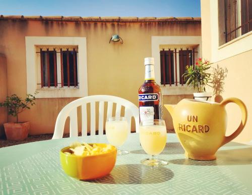 - une table avec une bouteille de vin et deux verres dans l'établissement Maison de vacances L'Hôte Champêtre campagne arlésienne, à Arles