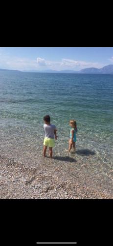 two children standing in the water on the beach at Villa sul Mare in Chalkida