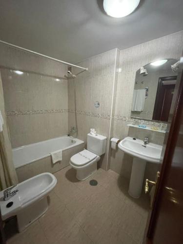 y baño con lavabo, aseo y bañera. en Hotel Valdés, en Gijón