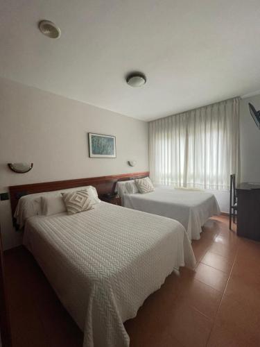 Habitación de hotel con 2 camas y ventana en Hotel Valdés, en Gijón
