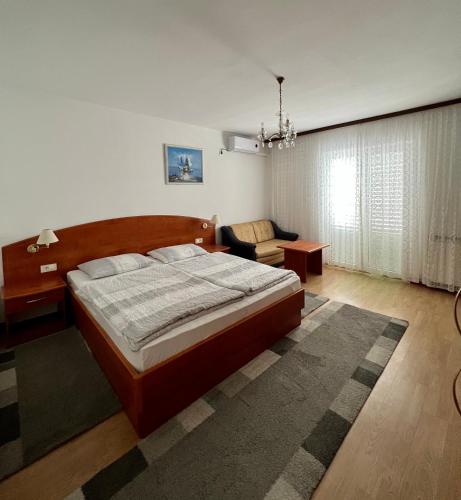 a bedroom with a large bed and a couch at Apartments Matušan in Rab