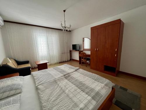 sypialnia z łóżkiem, krzesłem i biurkiem w obiekcie Apartments Matušan w Rabie