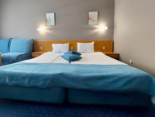 Un dormitorio con una cama grande con sábanas azules. en Aquamarine Hotel - All Inclusive, en Sunny Beach