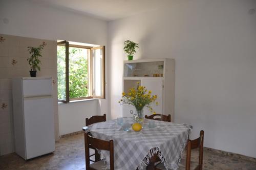 een keuken met een tafel met een vaas met bloemen erop bij B&B Fronte mare in Belmonte Calabro