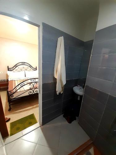 a bathroom with a shower and a toilet and a bed at Hotel salem leksor in Marrakech