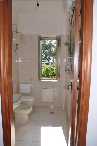 een badkamer met een toilet en een raam bij B&B Fronte mare in Belmonte Calabro
