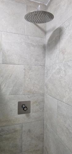 a bathroom with a shower with a stone wall at Old Center Inn Alicante in Alicante