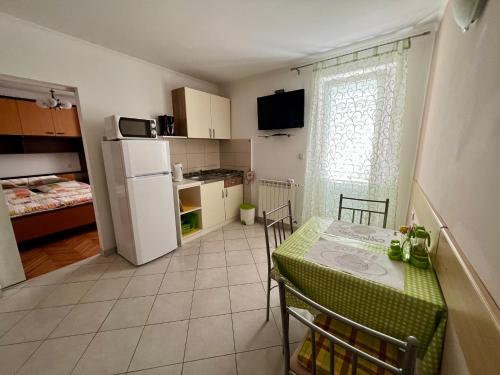 a small kitchen with a table and a refrigerator at Apartments Matušan in Rab