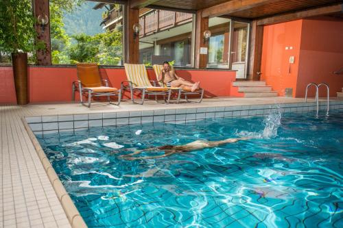 Eine Frau, die im Schwimmbad schwimmt. in der Unterkunft Relax & Vitalhotel Adler in Schruns-Tschagguns