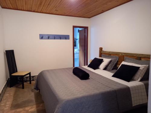 a bedroom with a large bed with black pillows at Pousada Serra Morena in Serra do Cipo