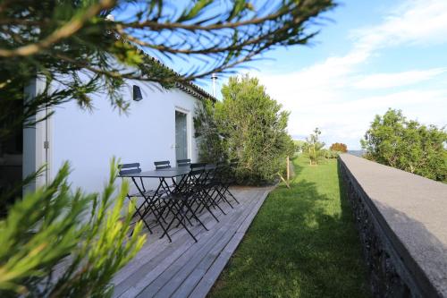 una terraza de madera con mesa y sillas. en Antiga Fábrica de Chá, en Nordestinho