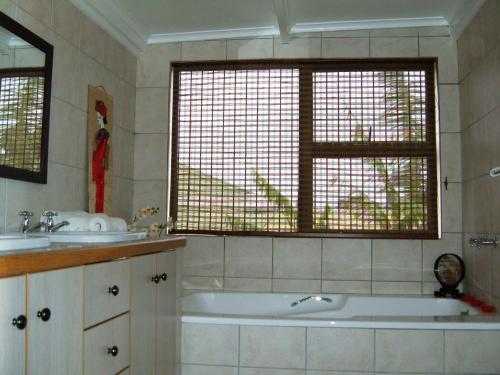 a bathroom with a tub and two sinks and a window at Smart Villa Guest House in East London