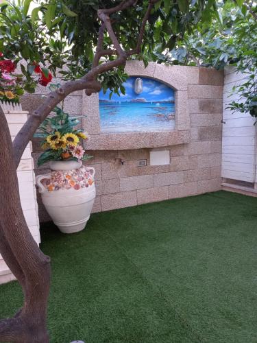 a patio with two vases and a wall with a picture at Zia Mia B&b in Olbia