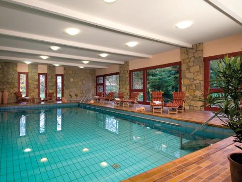 a large swimming pool in a building with at Landhotel Der Schwallenhof in Bad Driburg