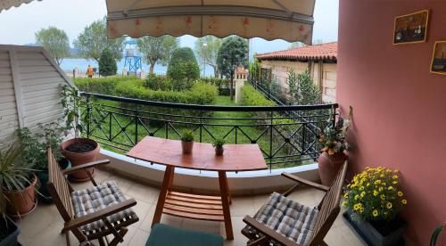 einen Balkon mit einem Holztisch und Stühlen sowie Aussicht in der Unterkunft Vivian’s apartment in Chalkida