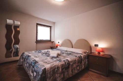 Residence Aquila - Bilo Punta Valfredda في بروسون: غرفة نوم بسرير كبير ومصبغتين ونافذة