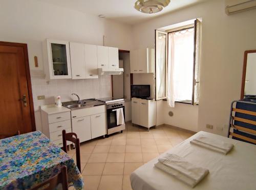 a kitchen with white cabinets and a table and a sink at La cortese - By Ligooria in Pietra Ligure