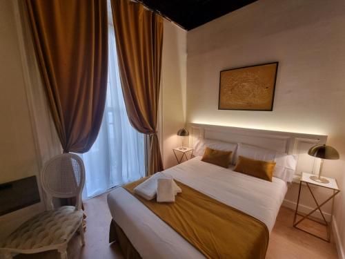 a bedroom with a large bed and a window at Le Petit Palü- Flora in Madrid