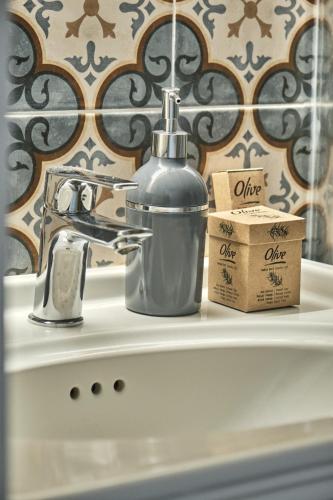 a bathroom sink with a bottle of soap and a soap dispenser at NO 35 Alaçatı in Alaçatı