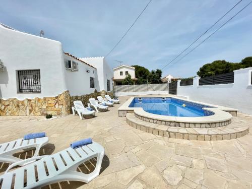 a patio with lounge chairs and a swimming pool at Villa Escaleta Costa dorada piscina salina y privada,barbacoa in Les tres Cales