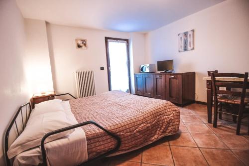 a bedroom with a bed and a tv and a chair at Residence Aquila - Mono Le Tre Dame in Brusson
