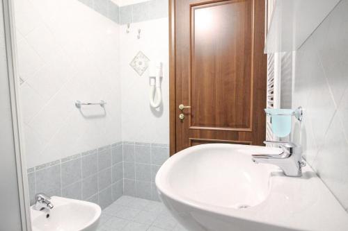 a white bathroom with a sink and a toilet at Residence Aquila - Mono Le Tre Dame in Brusson
