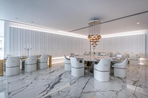 une salle à manger avec une table et des chaises blanches dans l'établissement Diamond Deluxe Hotel - Adults Only, à Kos