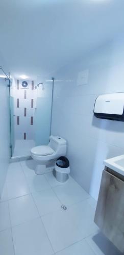 a white bathroom with a toilet and a sink at Ocean blue Ed Conquistador in Cartagena de Indias