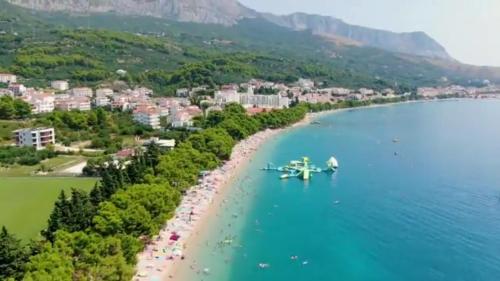 a plane flying over a beach with a resort at Apartments IKO in Tučepi