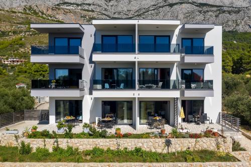 an aerial view of a house with mountains in the background at Apartments IKO in Tučepi