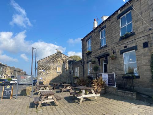 un groupe de tables de pique-nique à l'extérieur d'un bâtiment dans l'établissement The White Swan, Yeadon, à Yeadon