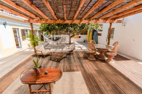 a patio with a table and chairs on a wooden floor at LemonTree Eco Surfhouse in Sagres