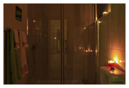 łazienka z prysznicem i świecą w toalecie w obiekcie Vannimar Lounge w mieście Porto Novo